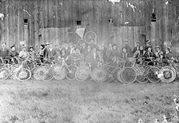 Black and white historic photo of people with their bikes