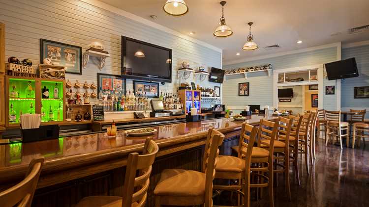 Interior of Gators Den Sports Grill with chairs in front of the bar and University of Florida decorations on the wall