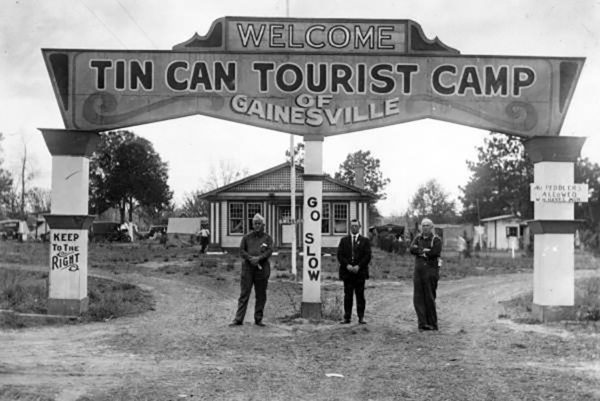 Old image from around 1920 of a large sign reading "Tin Can Tourist Camp, Gainesville, FL"