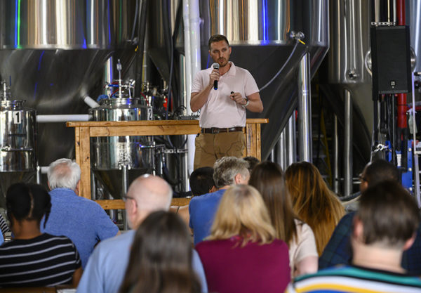 Scientist speaking to a crowd at the brewery
