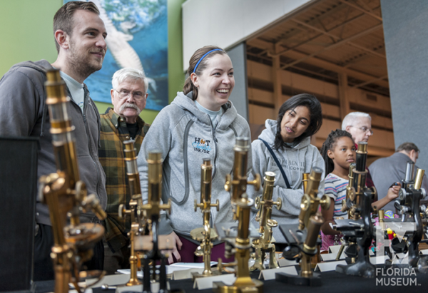 people looking at microscopes on a table