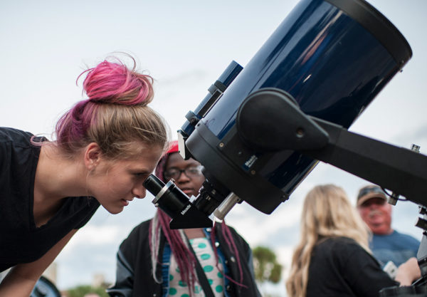 Woman looking through telescope