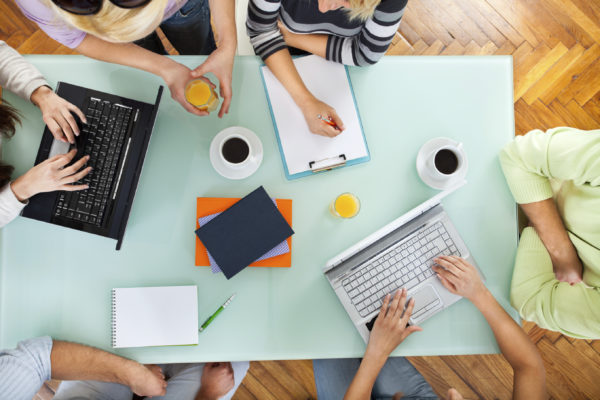 Overhead view of multiple people working together on a table