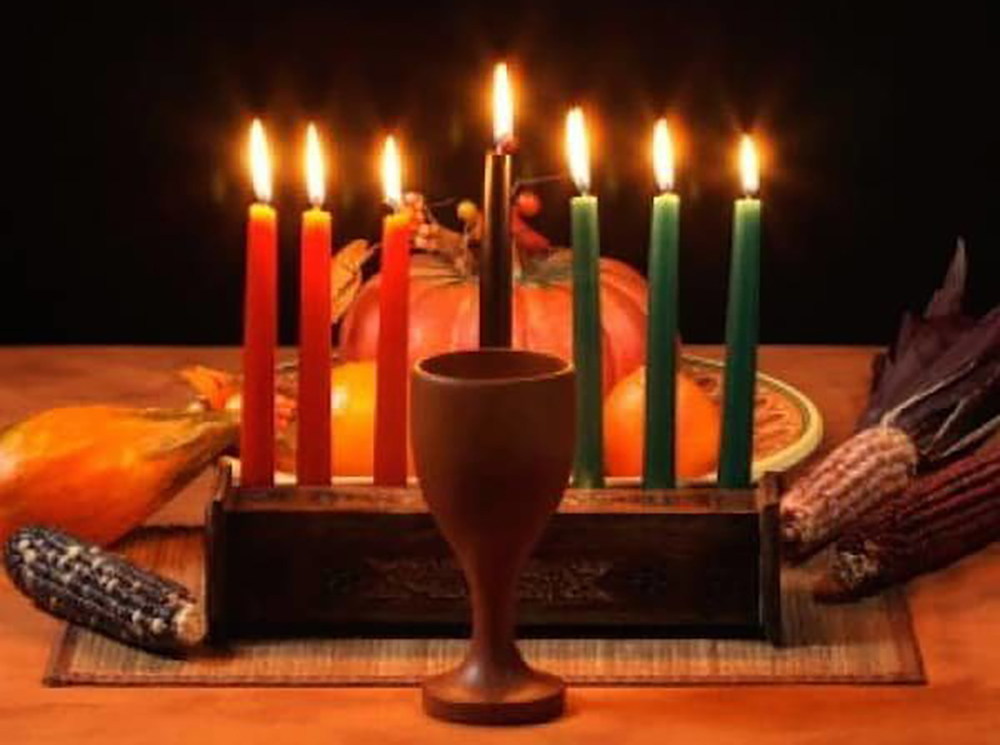 Traditional Kwanzaa table setting with Kinara with seven lit candles