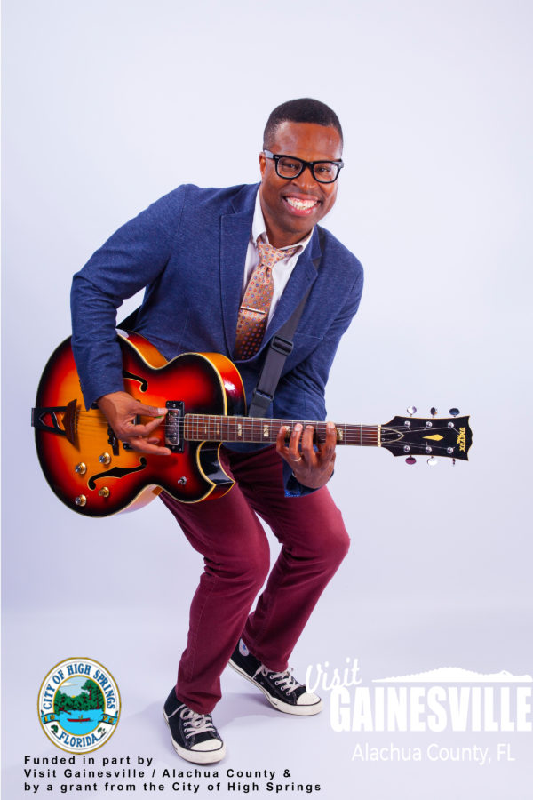 Billy Buchanan smiling and playing guitar