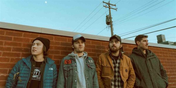 Band members of Michigan Rattlers standing in front of a brick wall