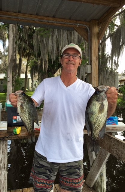happy fisherman holding up his catch in each hand