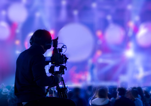 camera operator filming into lights of an event