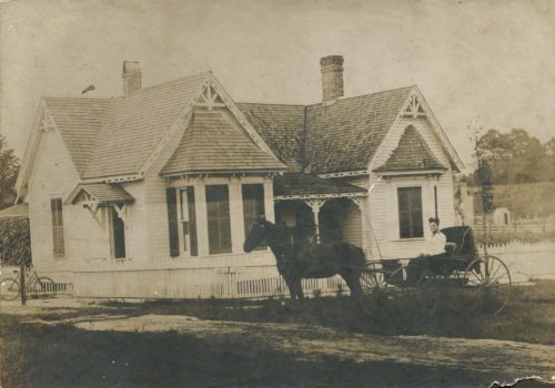 historic image of horse and carriage in front of house