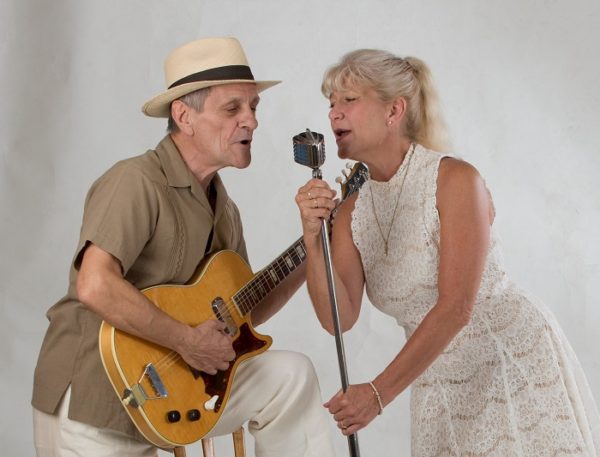 musicians singing into microphone