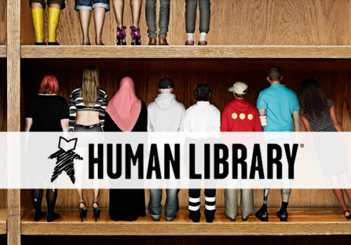 People lined up on a book shelf with the Human Library logo
