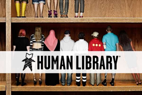 People lined up on a book shelf with the Human Library logo
