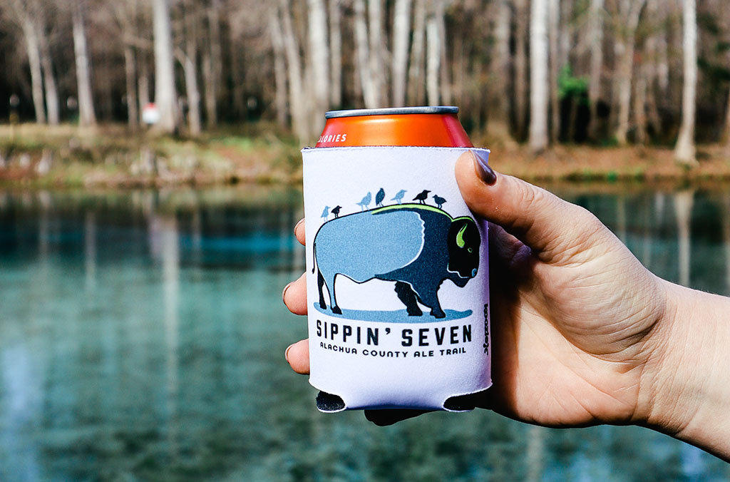 hand holding a sippin seven koozie