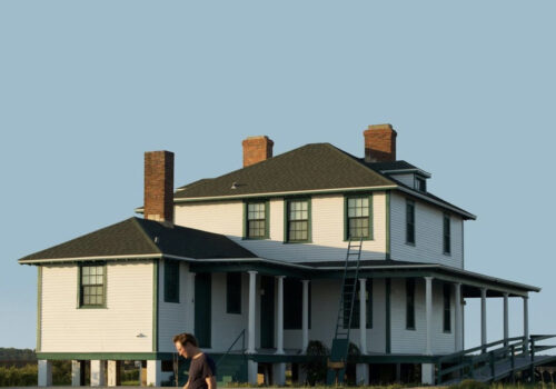 Blue sky with a white house with a black roof
