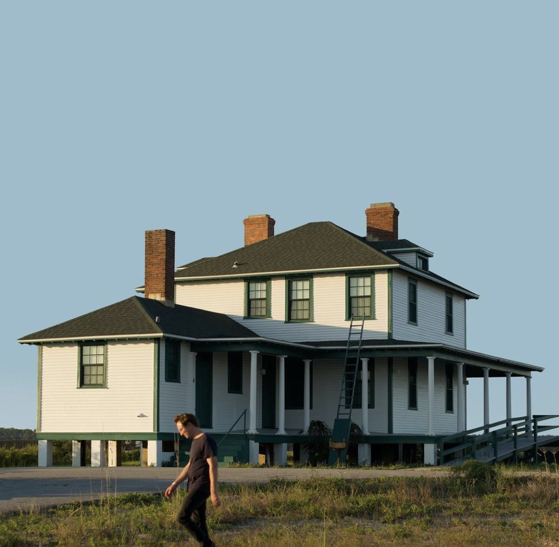 Blue sky with a white house with a black roof