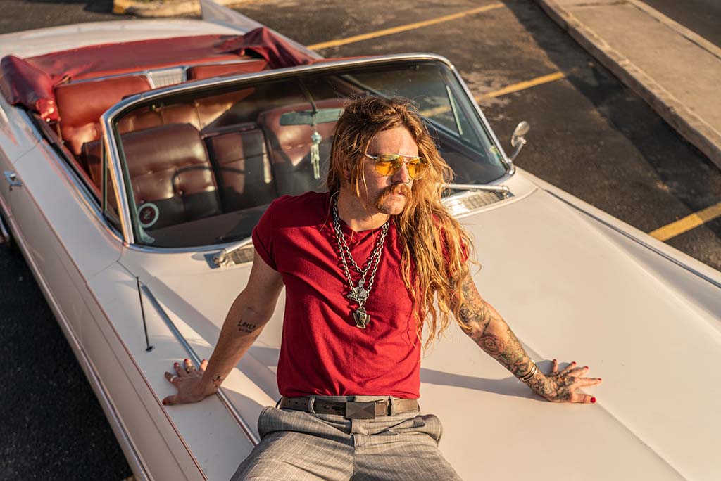 austine meade sitting on a car