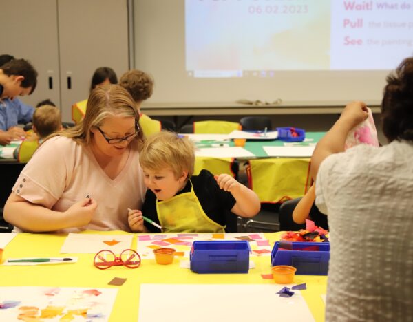 child and parent working on an art project