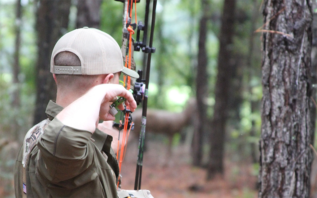 bow hunter aiming at 3d target
