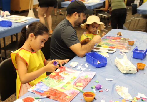 family with kids at table enjoying an activity