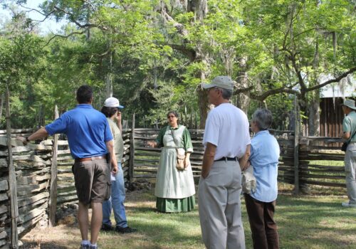 lady in period dress leading a group of visitors
