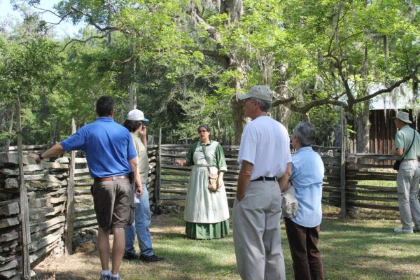 lady in period dress leading a group of visitors