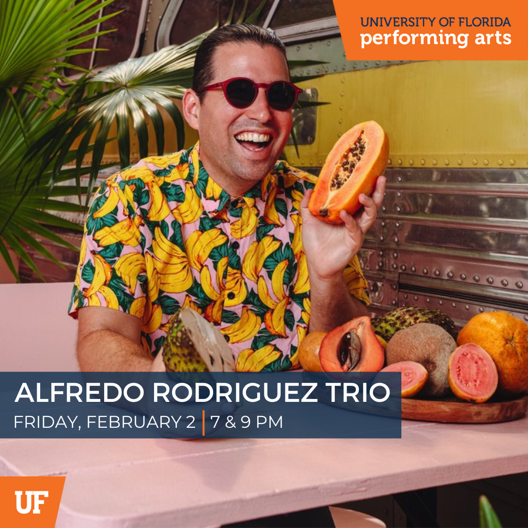Image of Cuban pianist Alfredo Rodriguez in a bright shirt holding a papaya