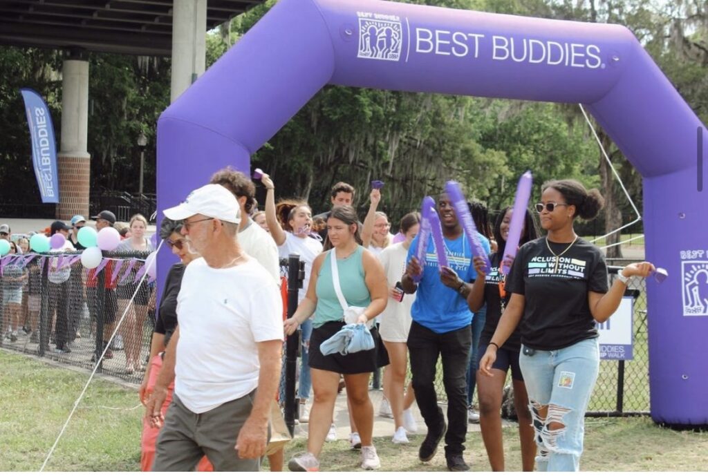 people walking under a best buddies inflatable gate