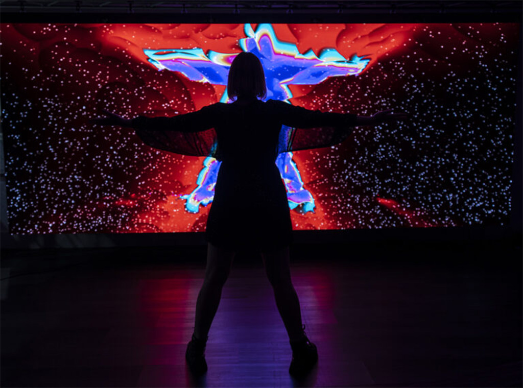 person in front of a interactive light display