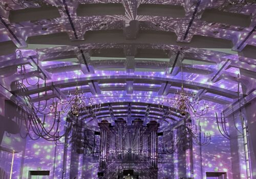 church organ with lightshow reflecting off of the ceiling