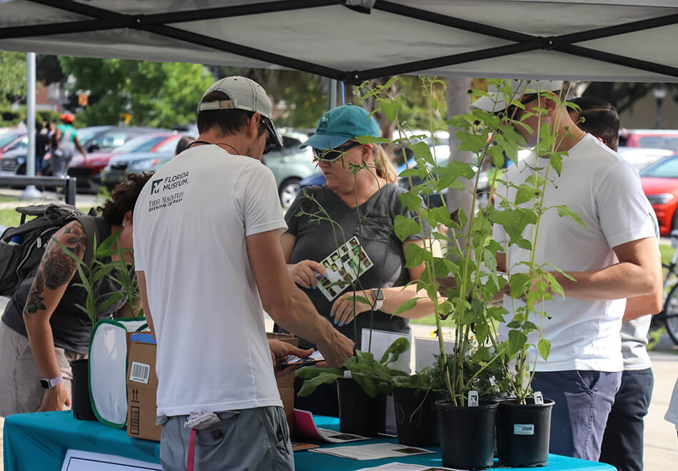 people gathered around an educational florida museum table plants