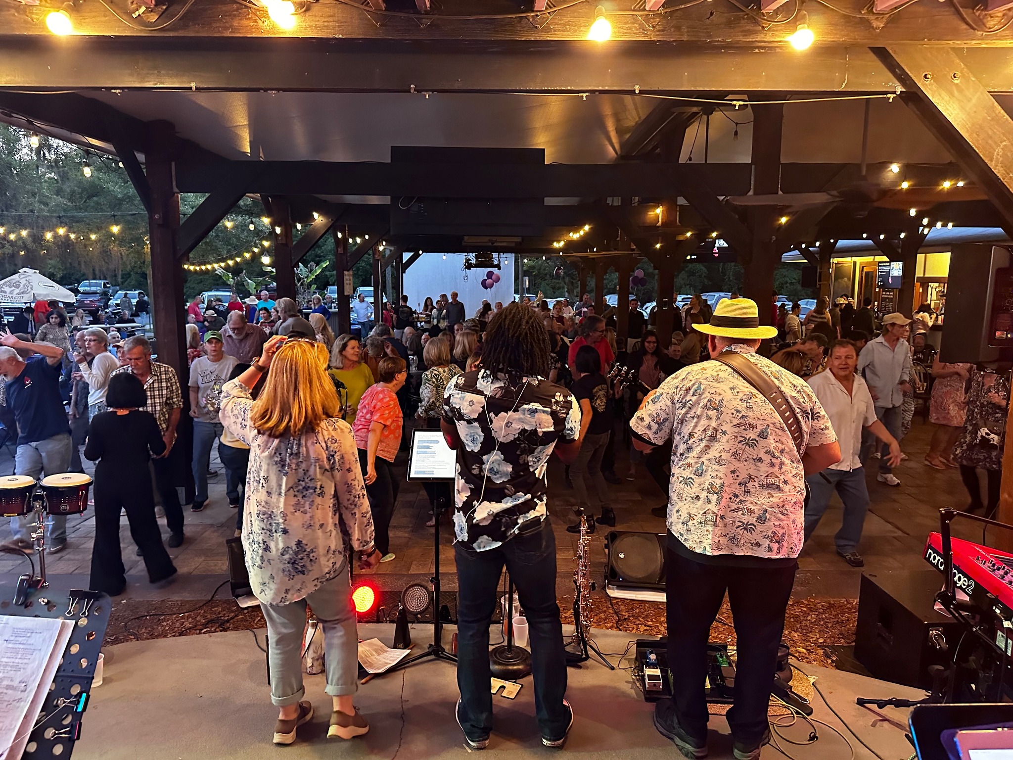 Image of Uncle Morty’s Rhythm Cream band performing live at an event with a crowd of people watching and dancing.