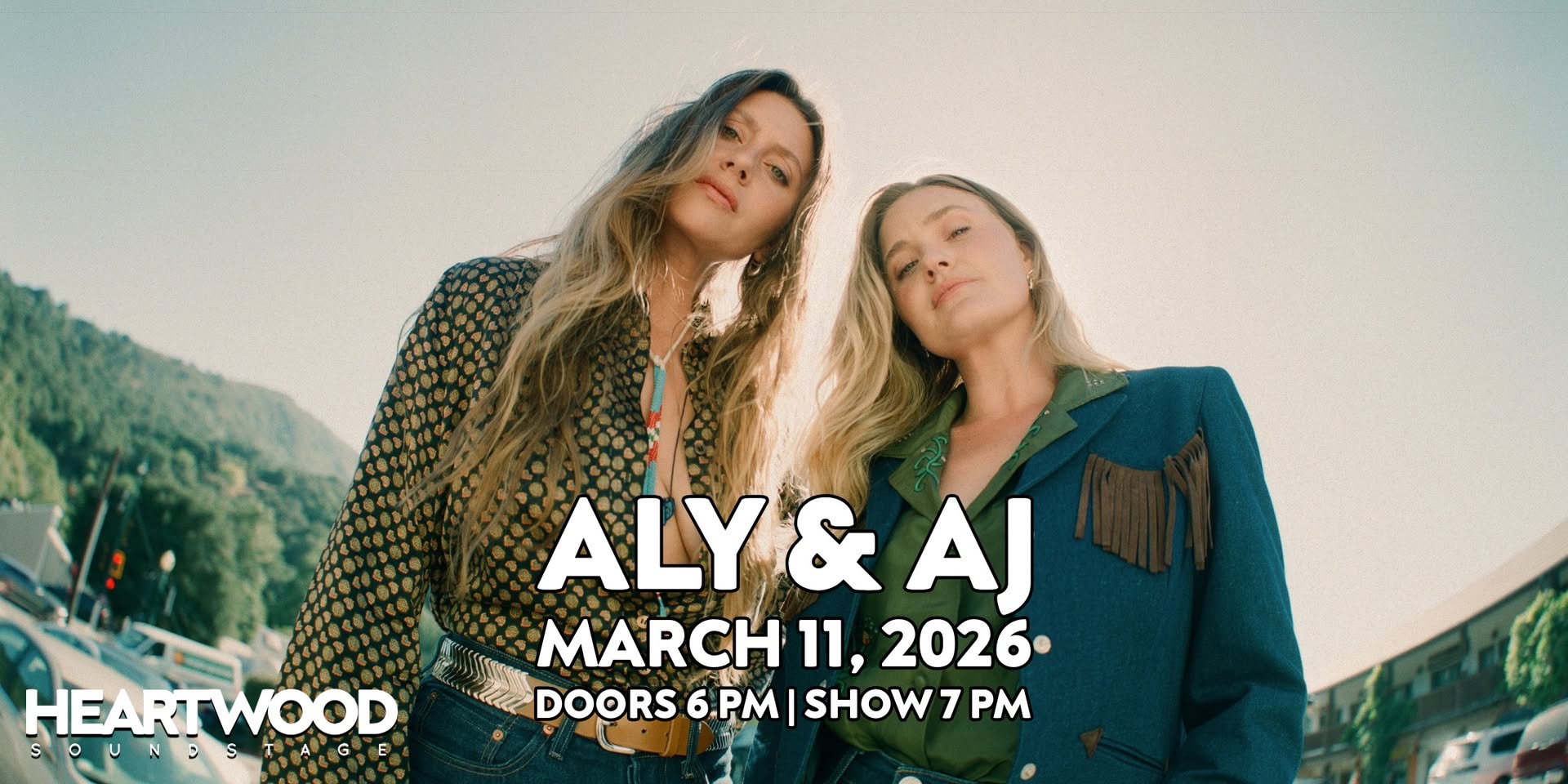 Event poster for Aly & AJ – Places to Run Tour 2026 at Heartwood Soundstage on March 11, 2026 at 7:00 PM. The image promotes an outdoor stage performance with lawn seating (lawn chairs allowed as space permits) and notes that kids 12 and under are free. Promotional quotes from Vanity Fair, NYLON, TIME, PASTE Magazine, and Atwood Magazine highlight the duo’s harmonies, longevity, and pop-indie sound.