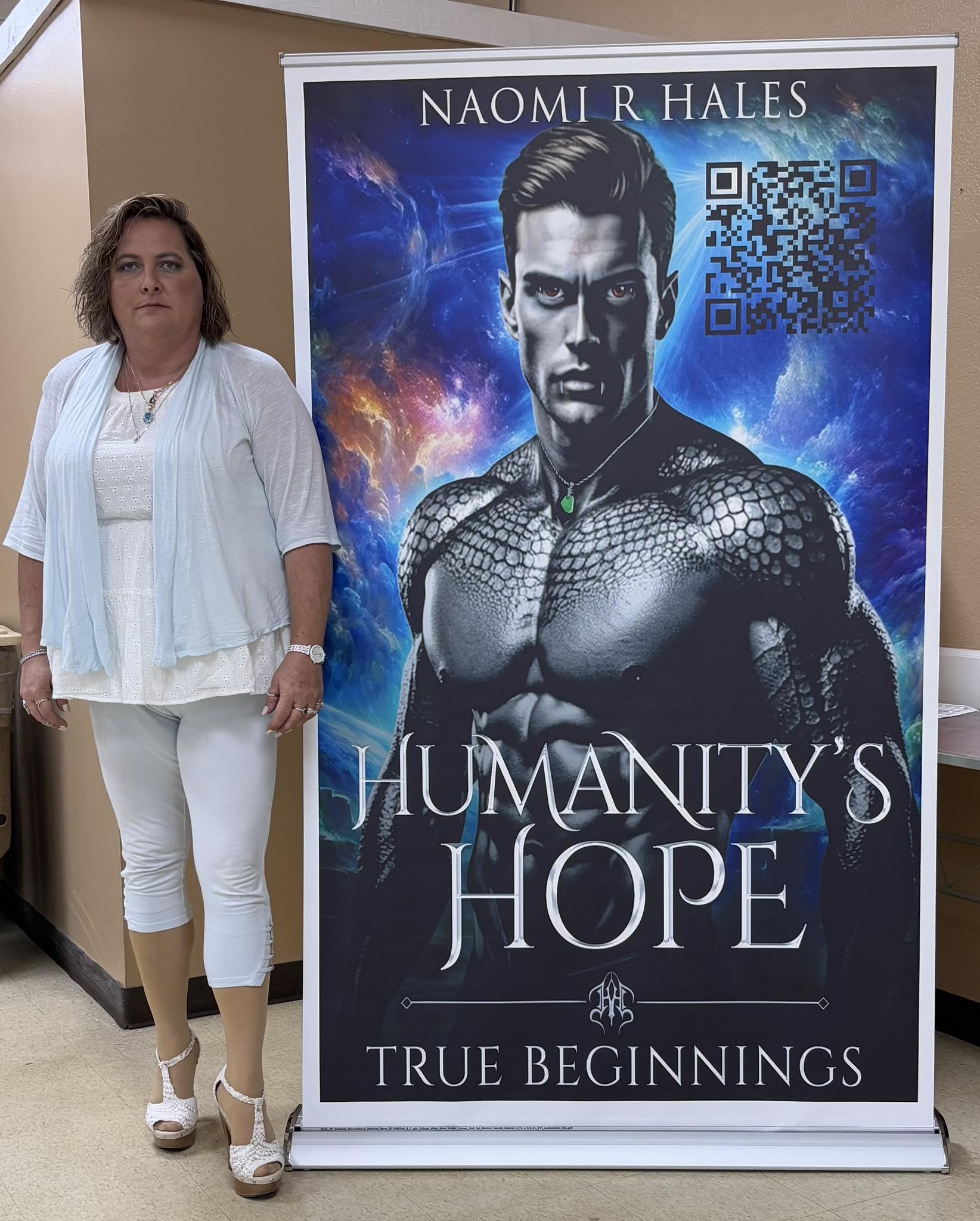 author standing next to book cover artwork
