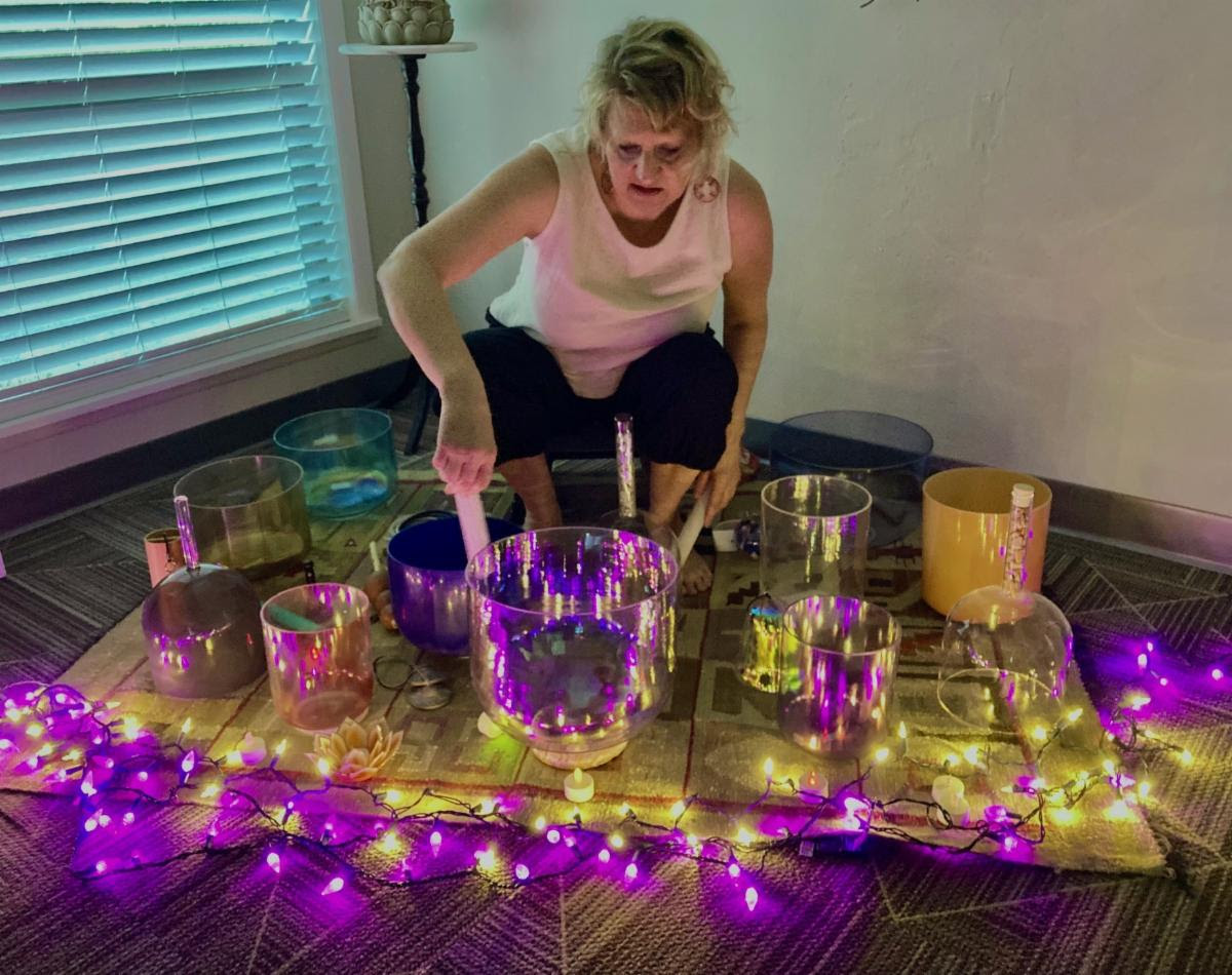 person performing with crystal bowls