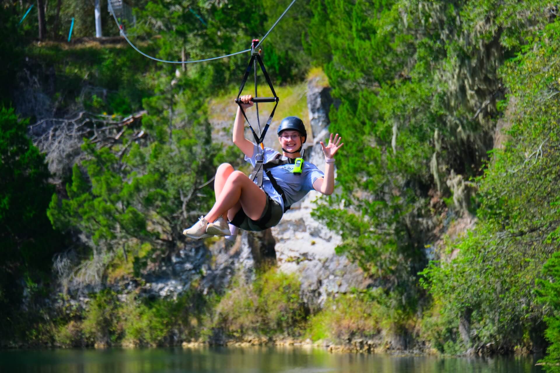 Woman zip-lining over water.