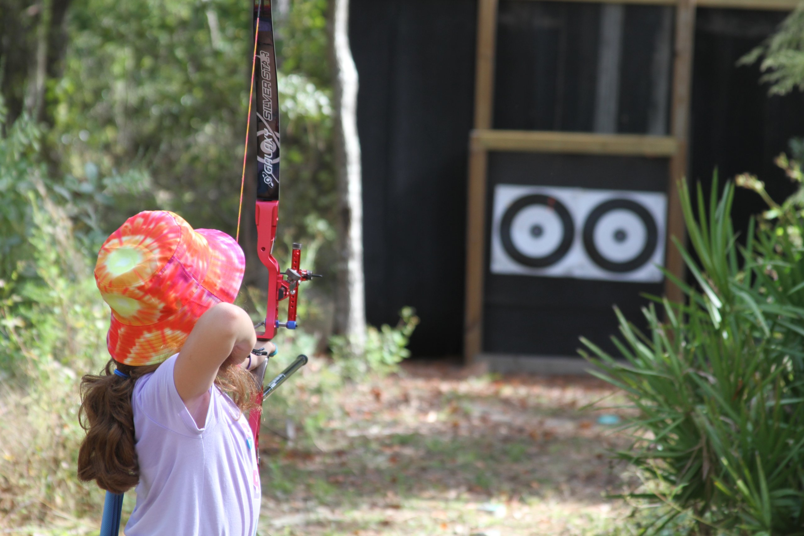 archer taking aim at outdoor targets