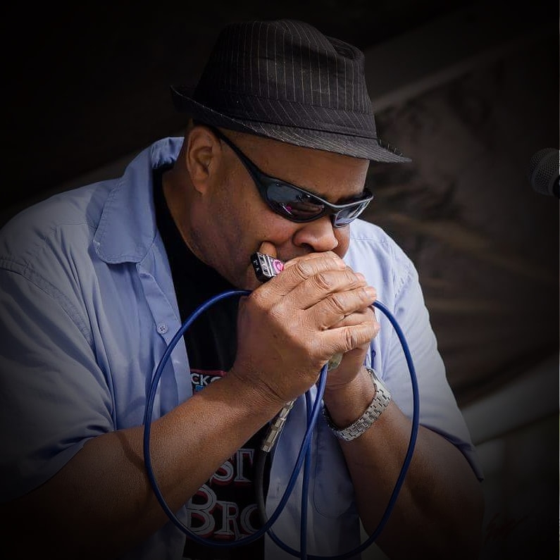 blues musician playing harmonica